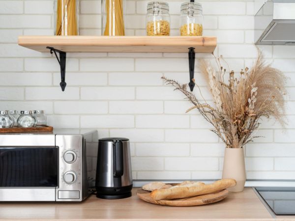 an oven with its door open, it is clean and there are some cleaning materials on the left