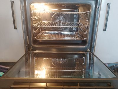 open oven that is clean showing the oven racks, the light is on