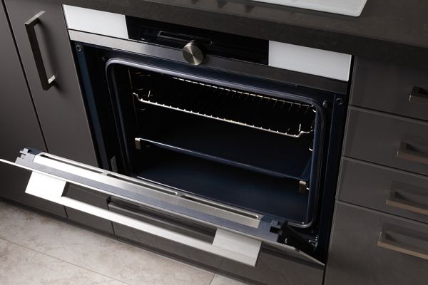 a built in oven with the door ajar, it is spotlessly clean, inciting it was professionally cleaned