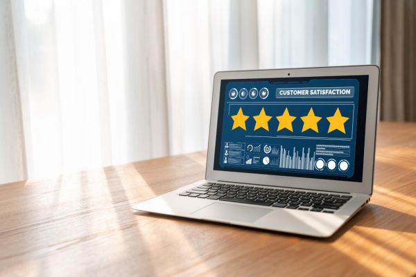 laptop on a table with a five starrating on the screen